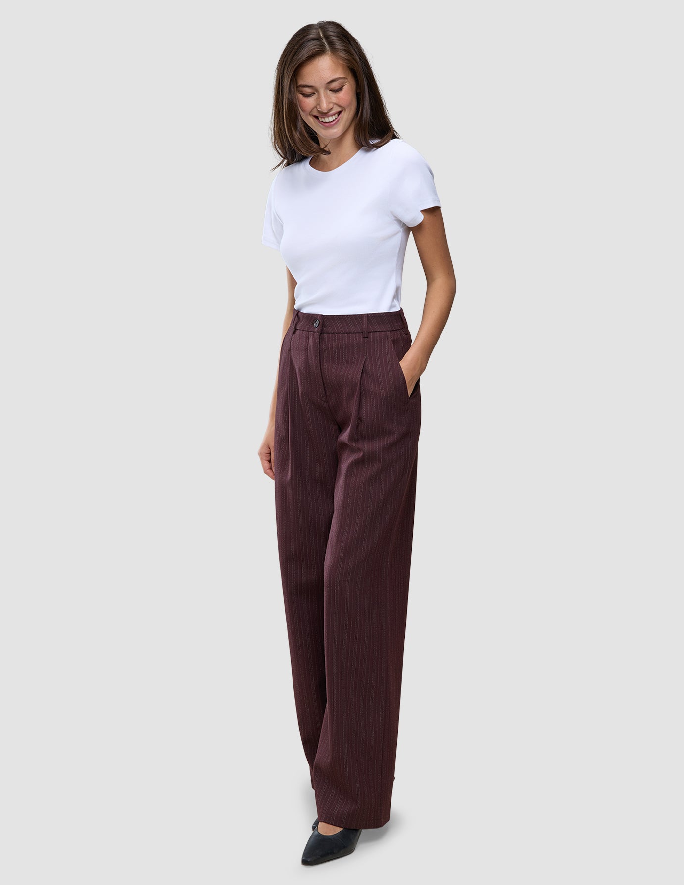 En kvinne har på seg en hvit T-skjorte og Women Serene Pants Wide Berry Pinstripe-bukser med vide ben.